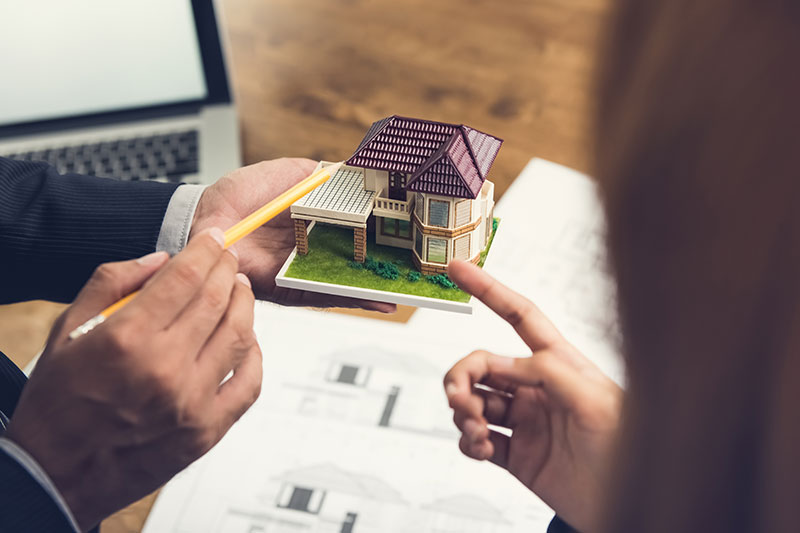 Immobilie bewerten in Hattersheim – Immobilienmakler erklärt Eigentümern die professionelle Wertermittlung anhand eines Hausmodells.